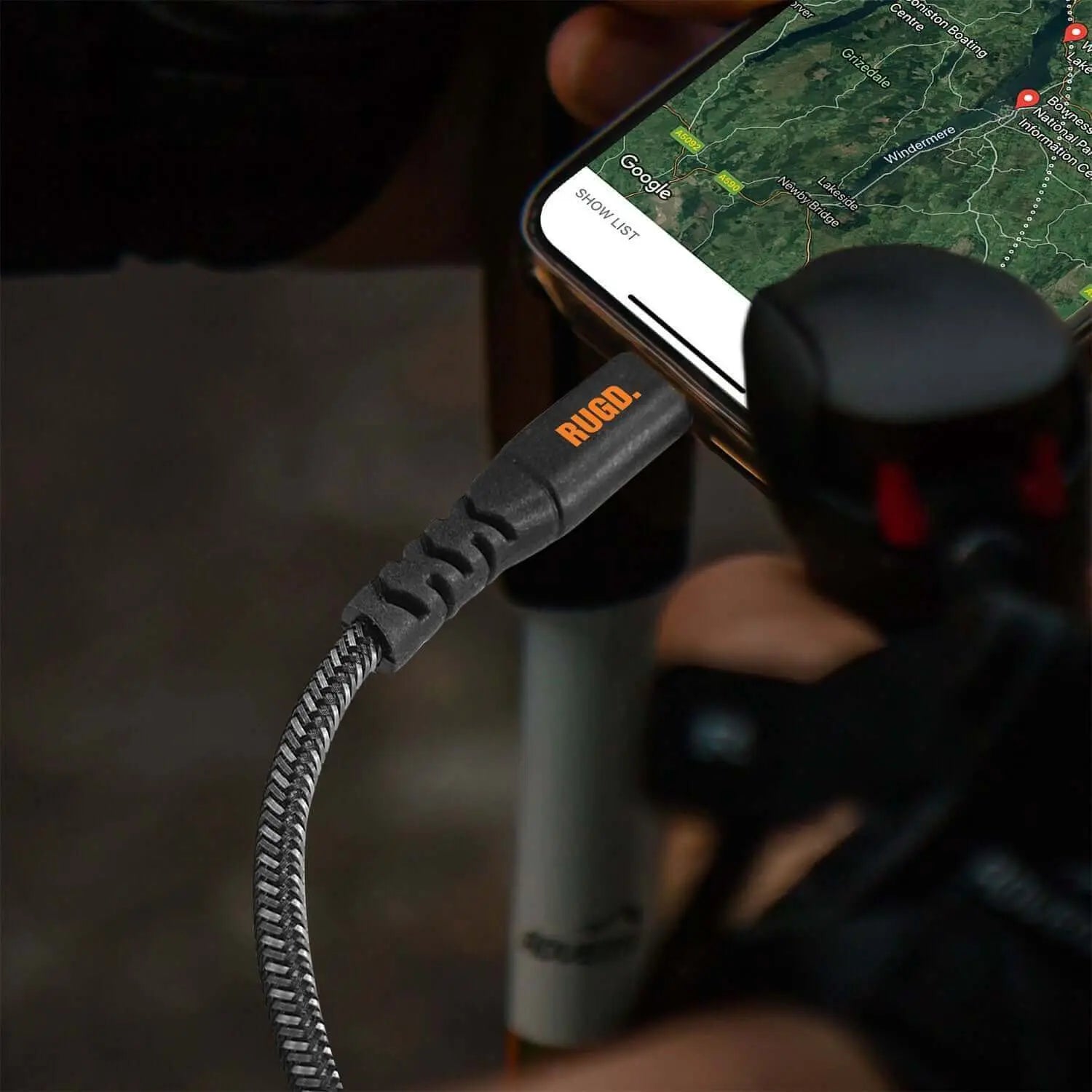 Rugged USB-C charging cable connected to smartphone during outdoor adventure.